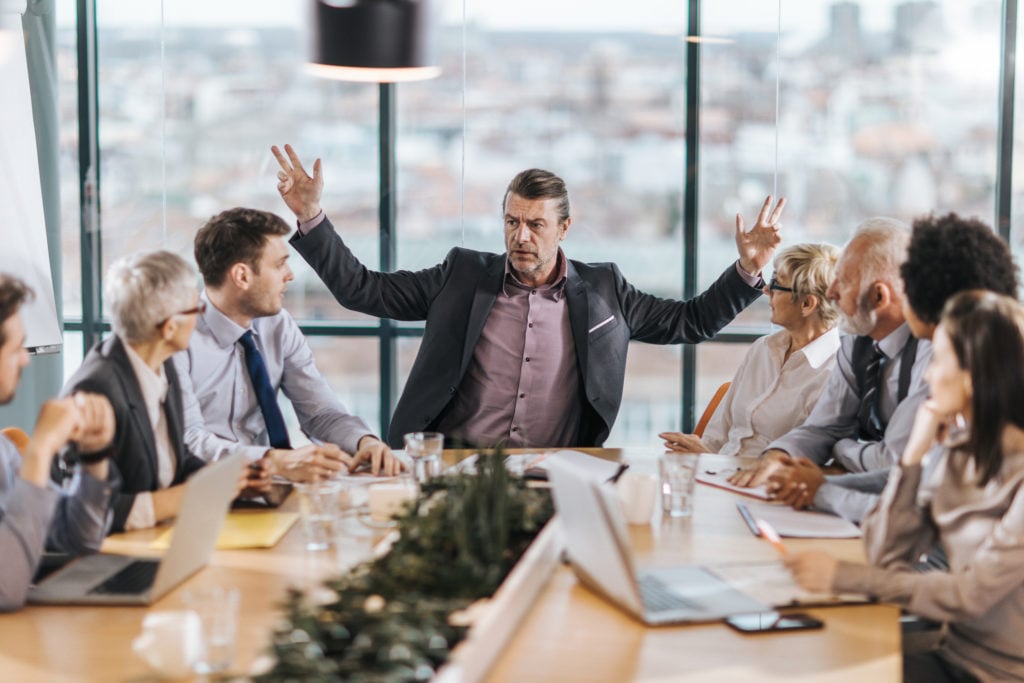 Frustrated manager arguing with colleagues in a meeting