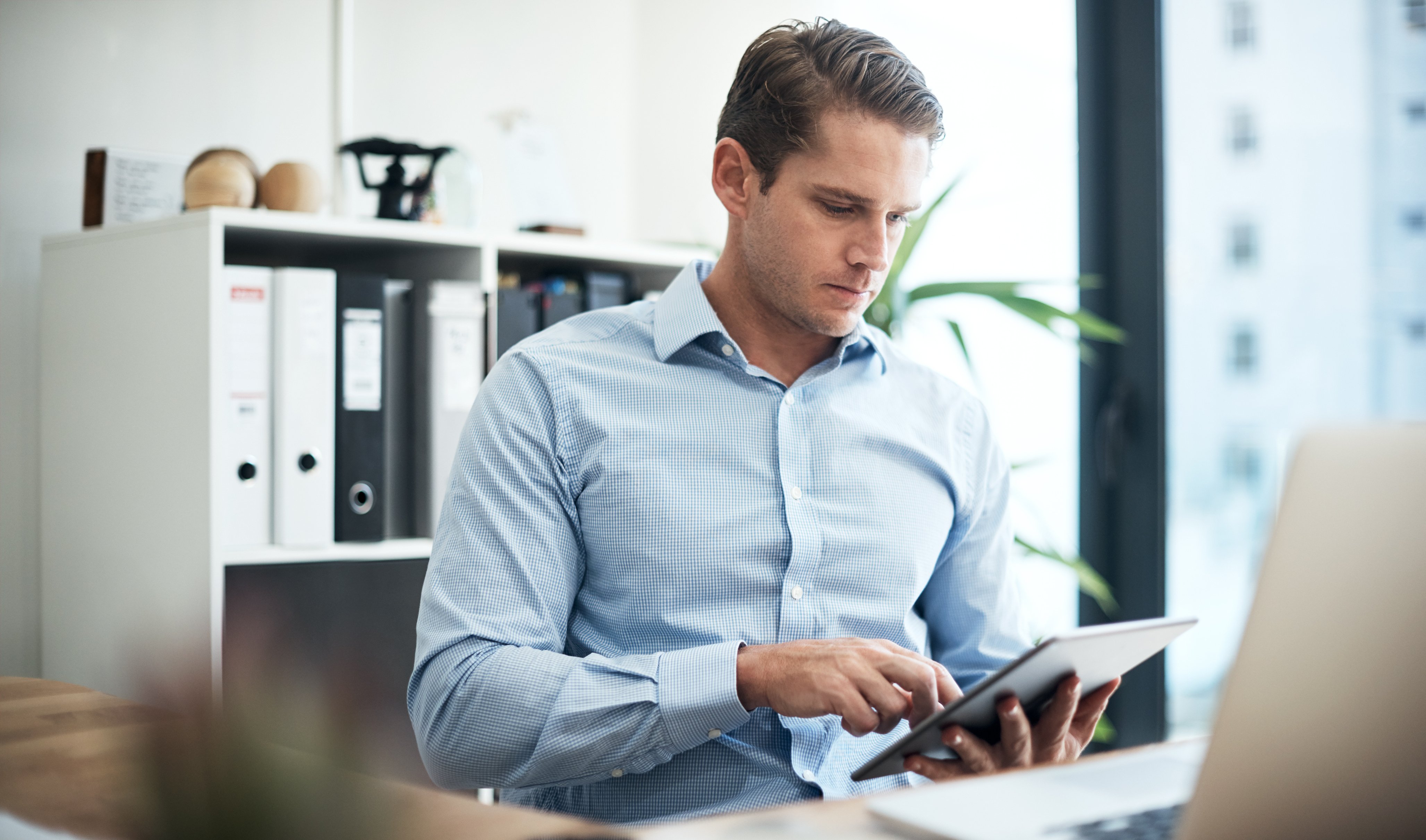 Young business man filling out survey on tablet